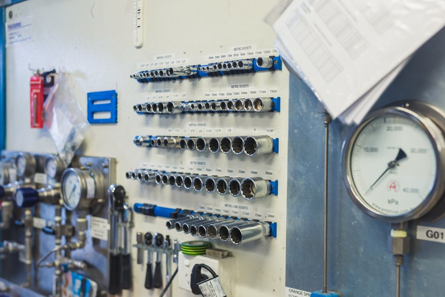 Haldatec cylinder test station tool wall with labelled socket sets and a high-pressure test gauge
